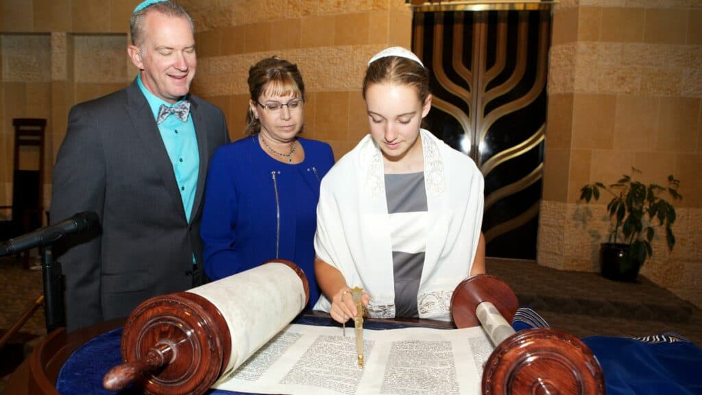 Bat Mitzvah on bimah reading Torah